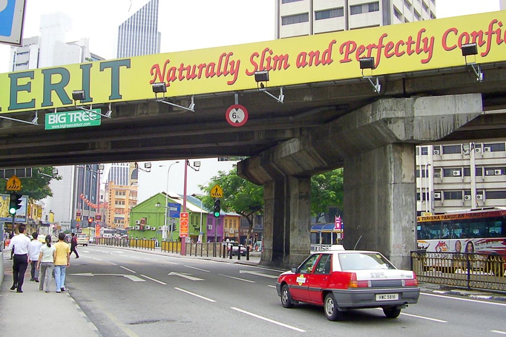 people-and-taxi-under-bridge-in-kuala-lumpur-street