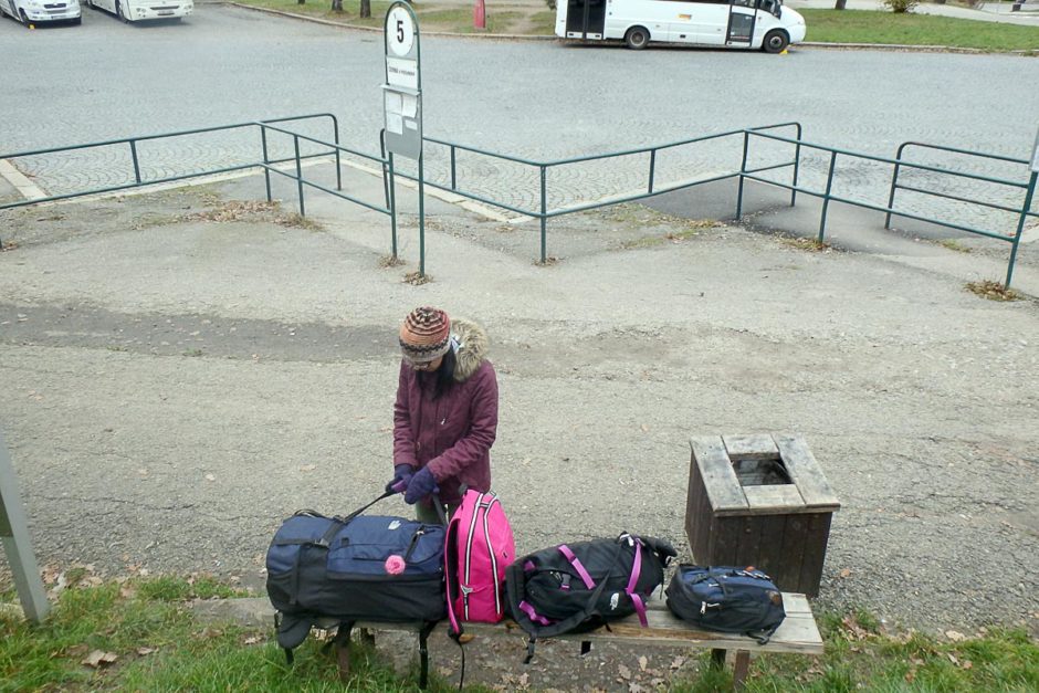 Masayo guards the bags at the bus stop.