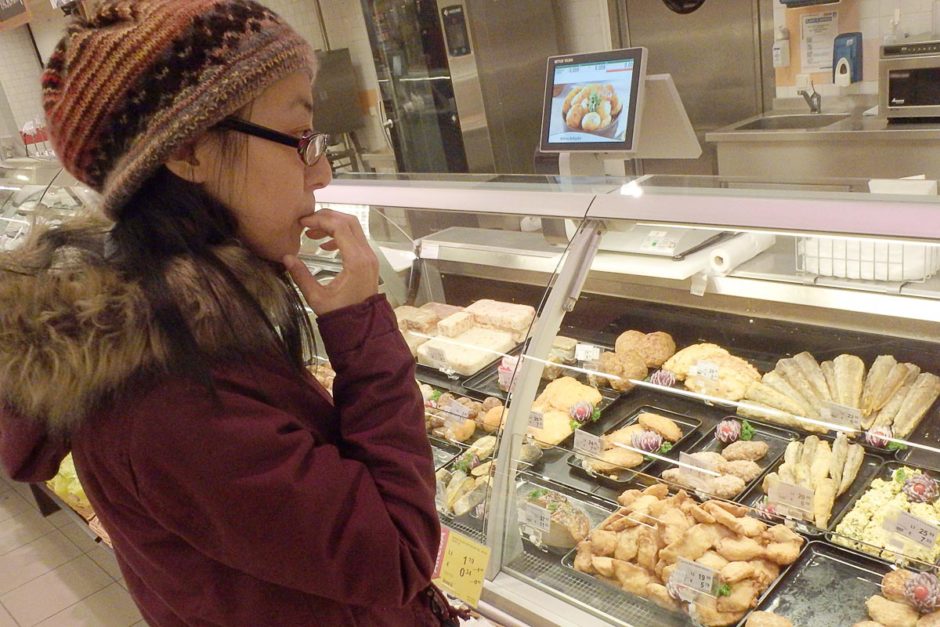 Masayo choosing a side from the deli at Rimi supermarket.