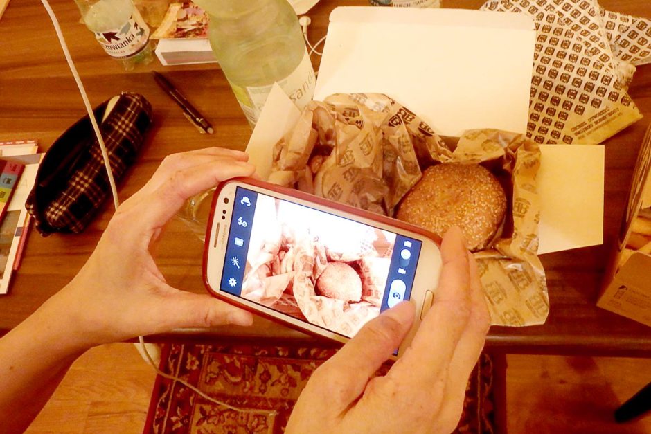 Masayo taking a photo of her hamburger meal.