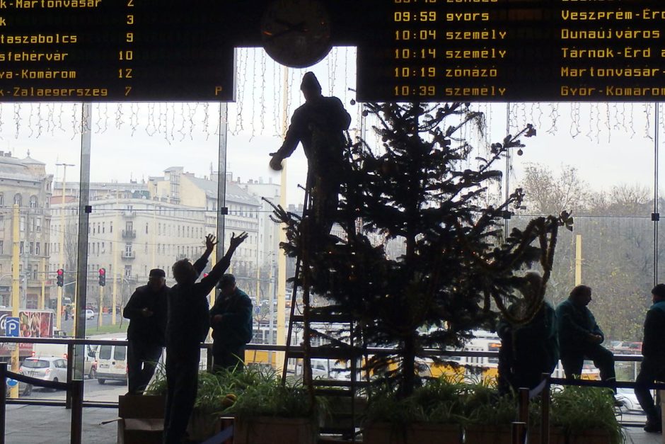 Several of the train staff were decorating the train station for Christmas. One guy was tossing an ornament to the guy on the ladder just as I snapped this photo of the train schedule board.