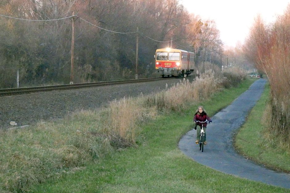 Masayo rides her bike as a train passes.