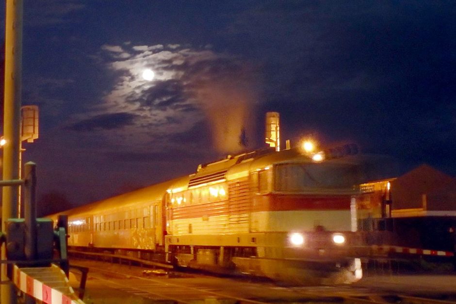 The full moon over a train going through Humenné.