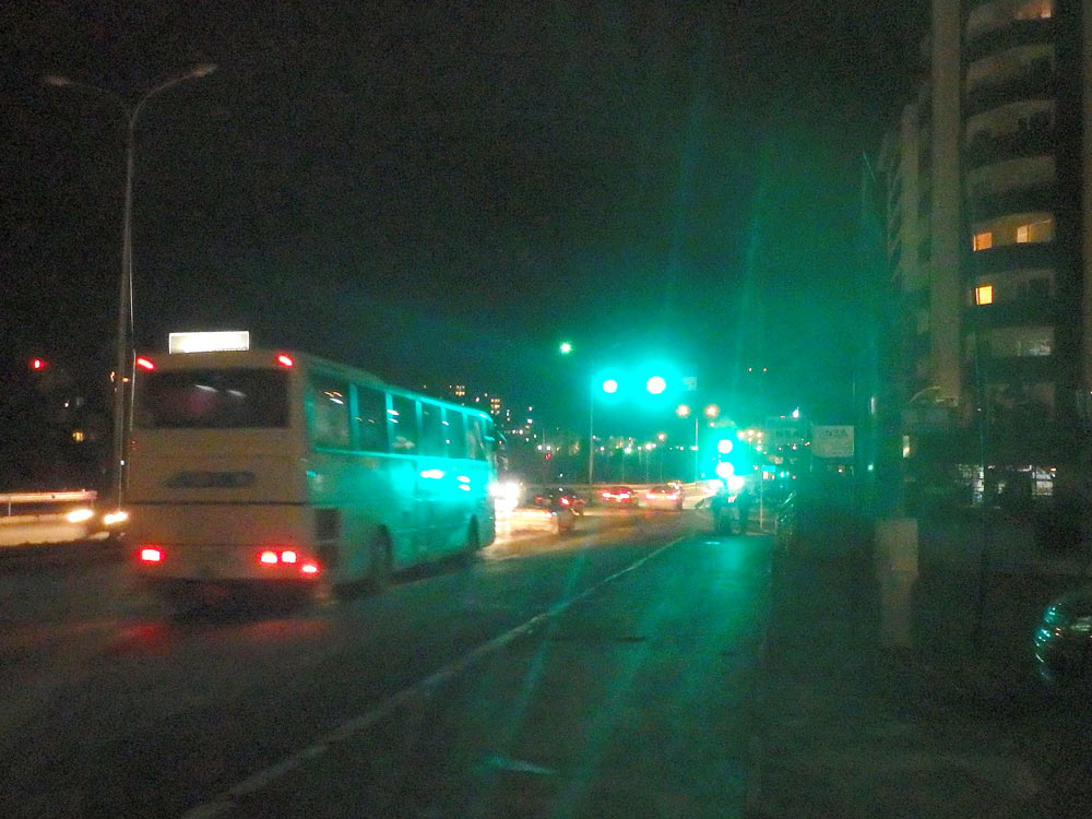The bus we arrived on leaves us on the side of the dark road in Prishtina, Kosovo