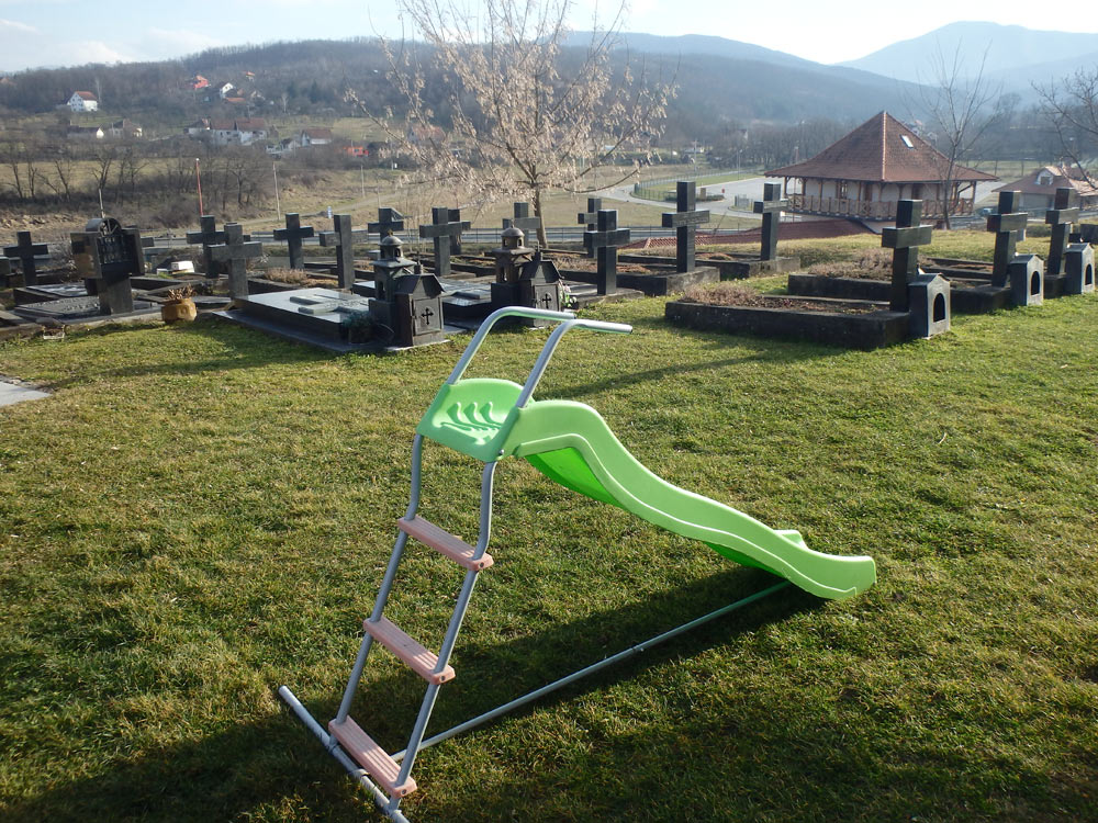 Child's slide in front of the graves at Žiča Monastery. "Go play in the graveyard, honey."