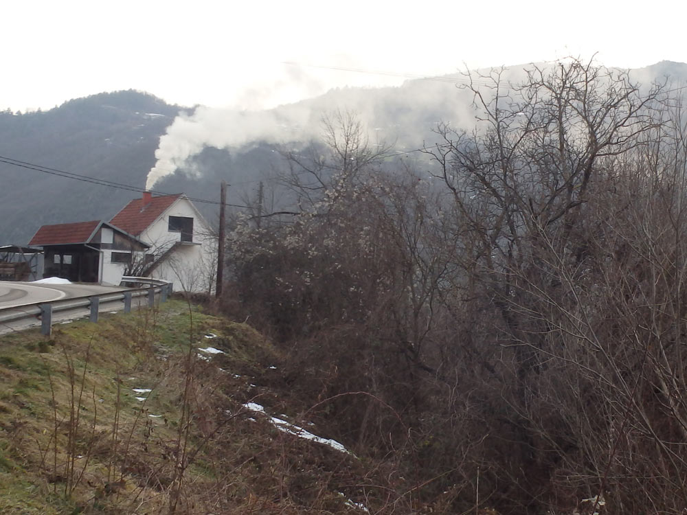 House with smoke coming from the chimney along the way.