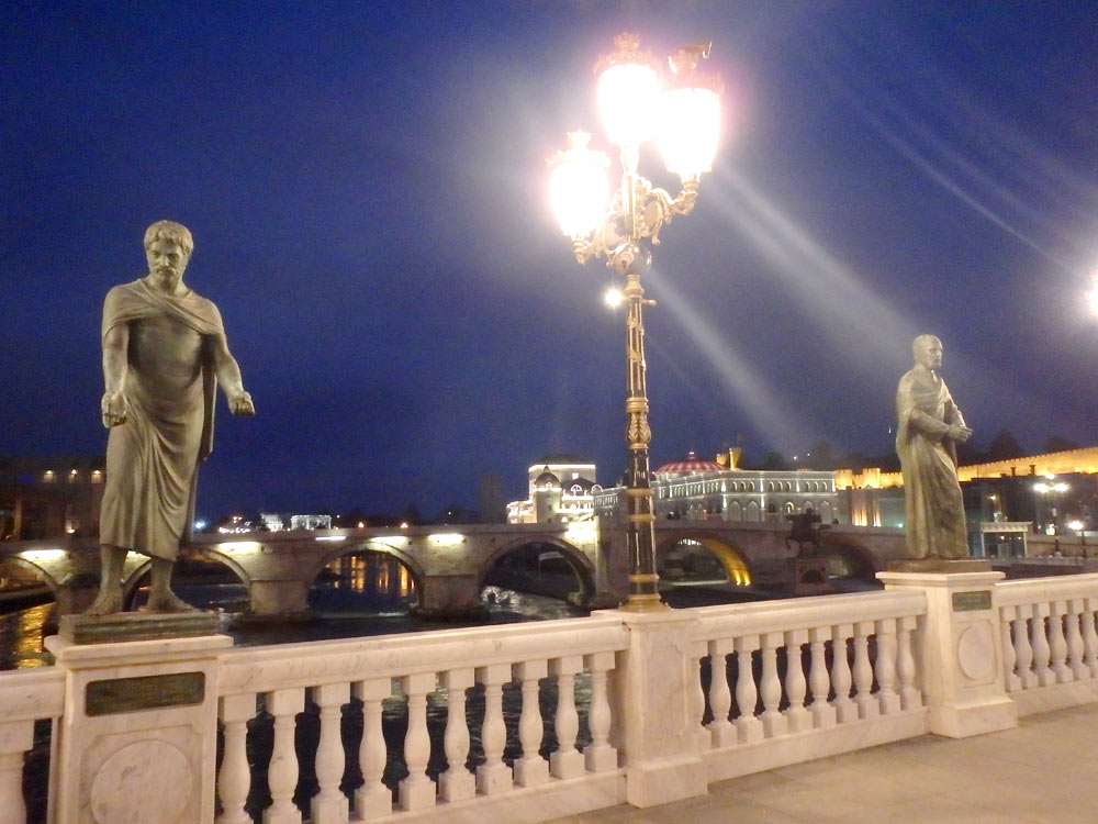 Lights and statues on bridge at night in Skopje