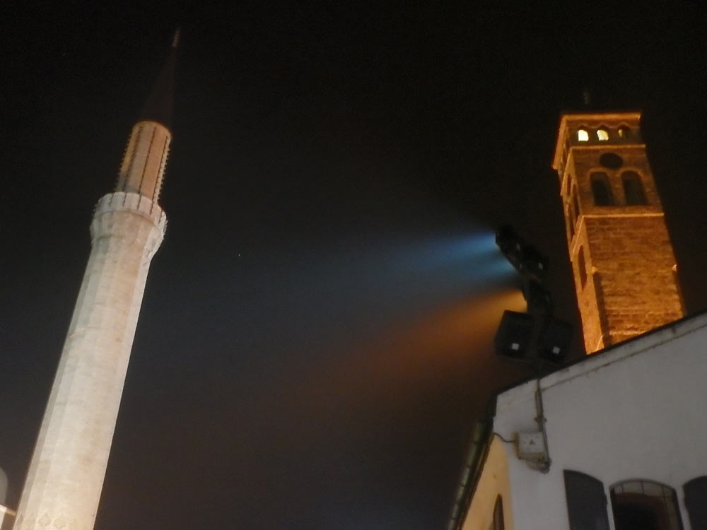 Mosque minaret and clock tower at night.