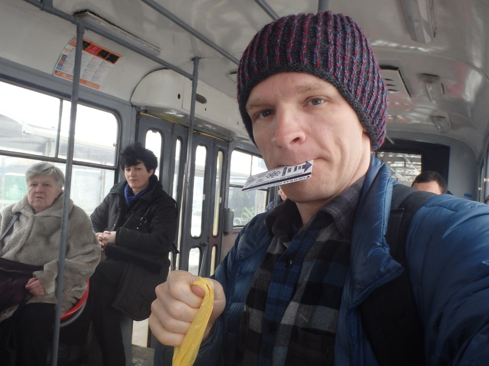 On a tram in Sarajevo, ticket in mouth. The locals don't seem so sure.