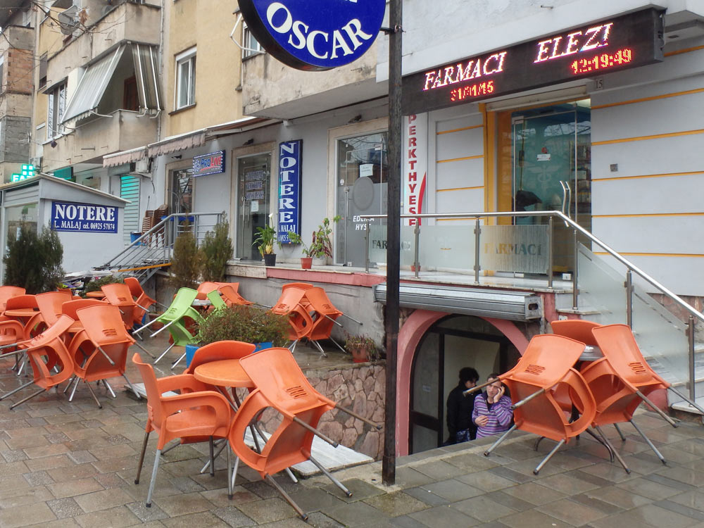 Orange chairs in the rain at a Tirana cafe