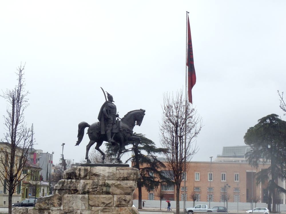 Tirana square statue and Albanian flag