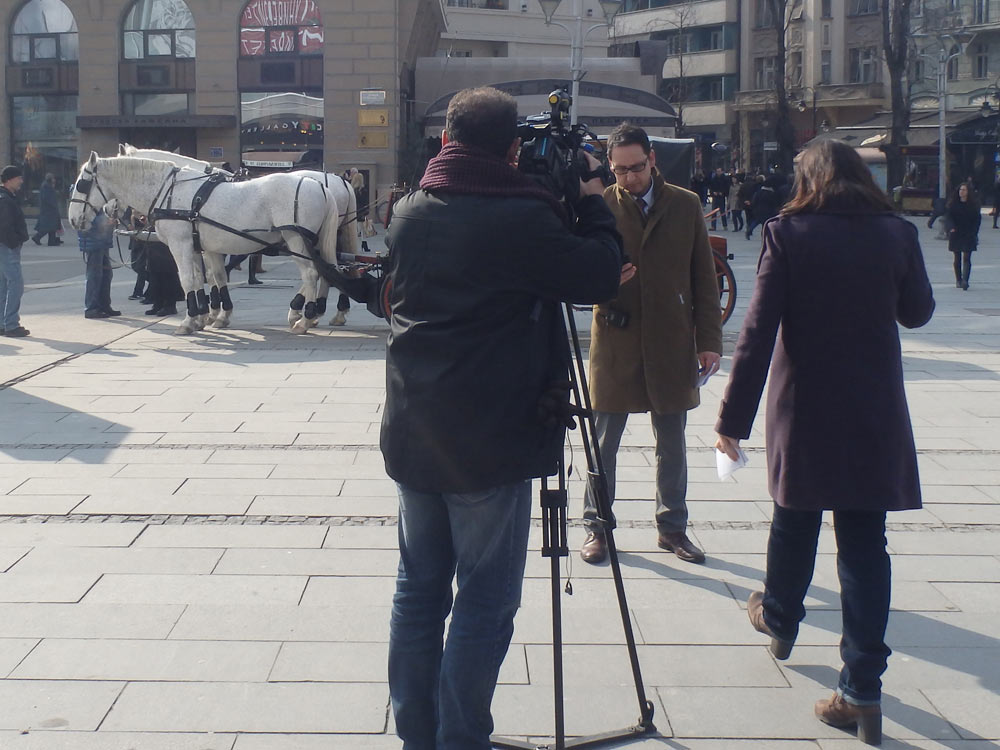 TV crew in the Skopje town square, with horses in the background