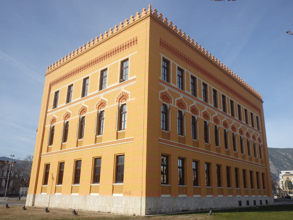 New yellow gymnasium building. Mostar is full of buildings like this alongside the burned and pockmarked shells of other structures.