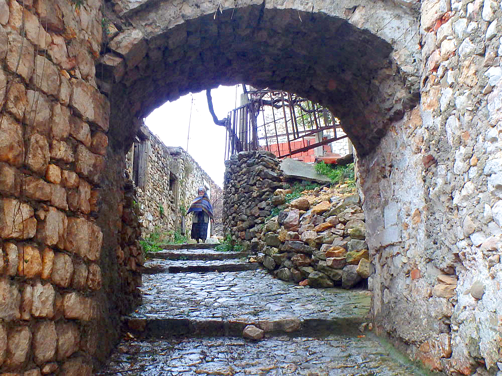 Archway in Old Town, with an old woman making her way down the path