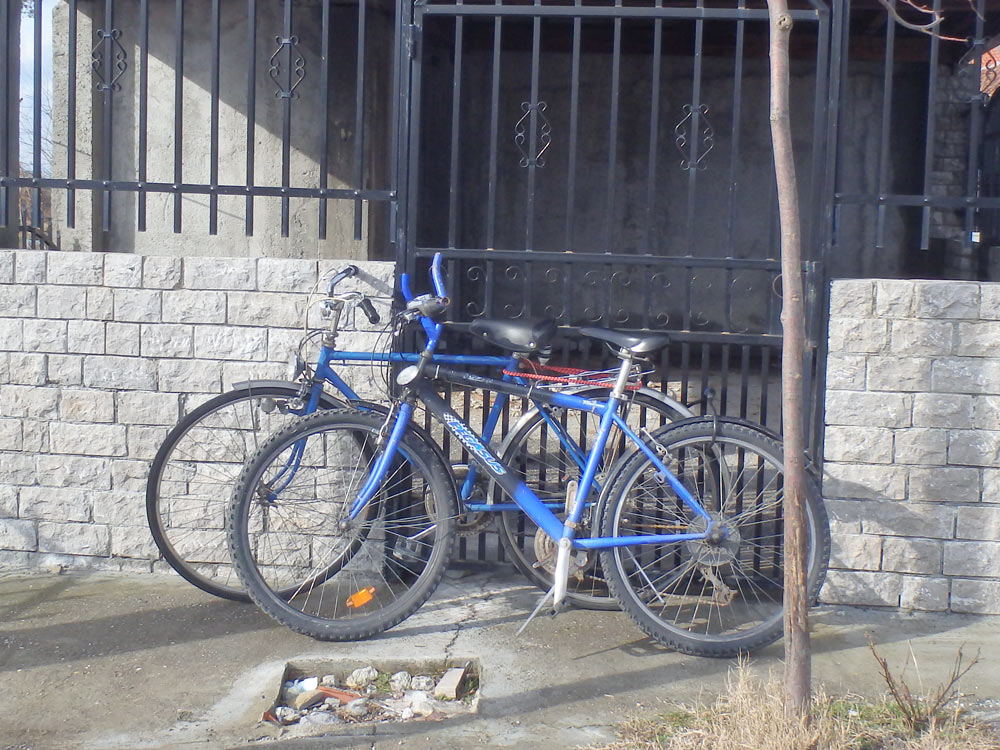 Bicycles chained to a building near Rozafa Castle
