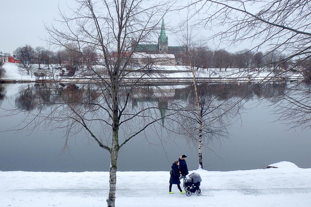 couple-with-baby-stroller-beside-river-trondheim