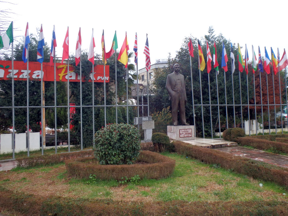 Multiple nations' flags on a street corner across from the abandoned tourist office