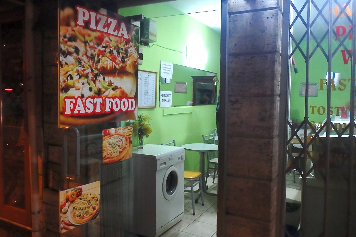 Pizza place with its own laundry machine in Albania.