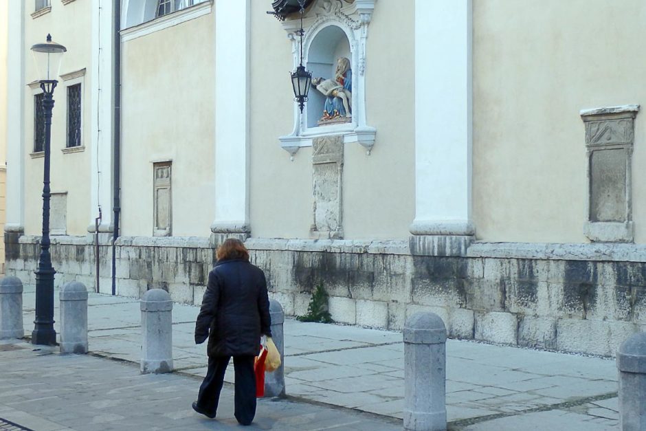 woman-walking-under-christian-relief-ljubljana