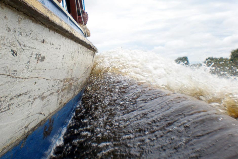 As Khmer kids in canoes do circles around my motorboat